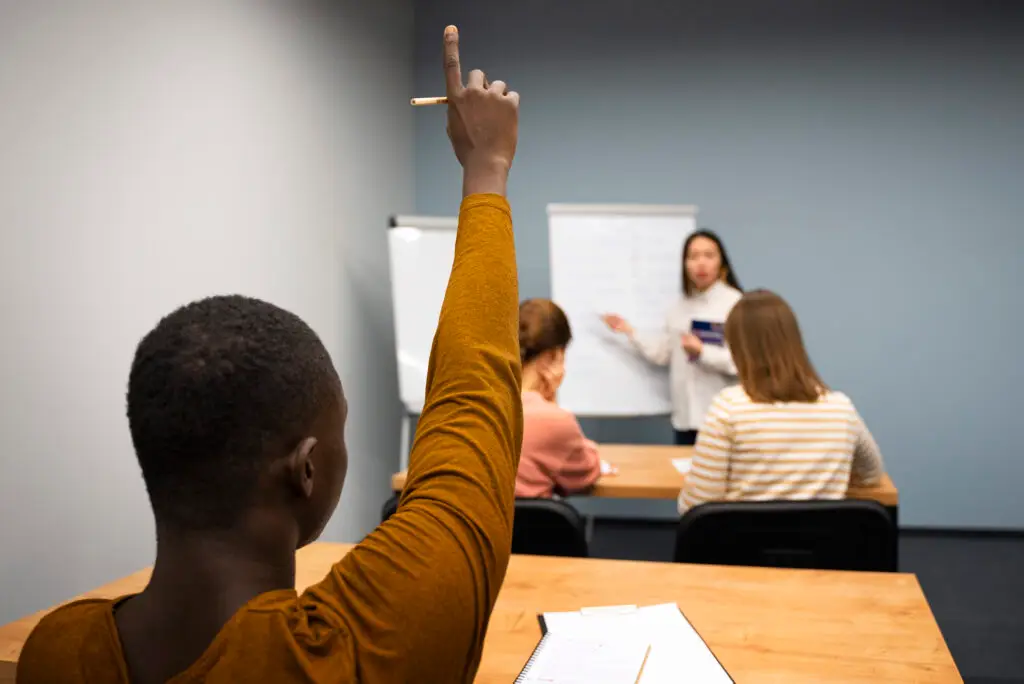 Someone raising hand in a class